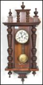 A late 19th Century Victorian Vienna wall clock having a white enamelled dial with roman numerals to