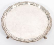 A 20th Century silver hallmarked tray / salver having a shaped rim raised on pad feet. Marked for