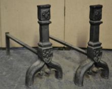 A pair of 19th century French cast iron fire irons having ebonised finish with ram head masks and