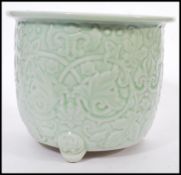A 19th century Chinese Celadon glaze planter raised on scrolled feet with decoration of swags and