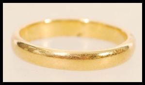 A 22ct gold wedding band ring being hallmarked to inner shank for Birmingham, Maker HS, Size Q.