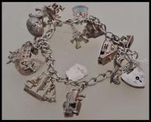 A silver hallmarked charm bracelet together with fifteen assorted charms to include a hinged