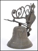 A vintage early 20th century Art Nouveau cast metal bell having cherub and shell mask decoration.