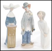 A group of three Lladro porcelain figures to include a Nun, girl and clown. Printed marks to base.