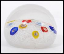 A 20th Century glass paperweight with random murrine canes atop a muslin ground cased in a clear