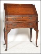 A 1920's Jacobean revival oak bureau desk being raised on cabriole legs with pad feet. Single