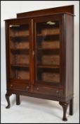 An Edwardian mahogany display cabinet vitrine. The cabinet being raised on shaped cabriole