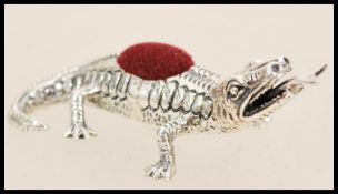 A stamped 925 silver pincushion in the form of a lizard with a forked tongue having a red cloth