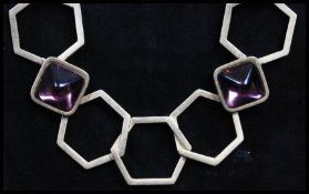 A 1970s signed YSL Yves Saint Laurent gold-tone runway necklace being strung with large geometric