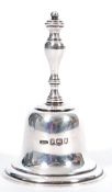 An early 20th Century silver hallmarked table bell by Asprey having a baluster formed handle and a