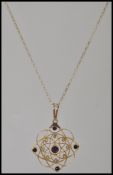 A 15ct gold Art Nouveau necklace and pendant chain being adorned with amethyst and seed pearls being