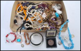 A good selection of costume jewellery to include and amber coloured bead necklace, a cloisonne