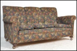 A 1920's Chesterfield 3 seat sofa settee being raised on bun feet with castors having barrel arms