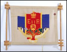 A vintage 20th century Royal QEII tapestry banner on turned wooden frame. 62cm high 74cm wide.