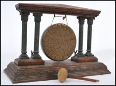 A 19th century oak and bronze table gong, the central hanging gong flanked by metal columns either