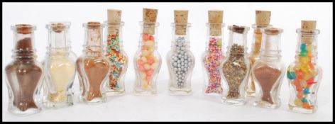 A selection of pressed glass apothecary bottles some having numbers to the bases, with cork