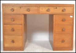 A vintage mid 20th Century Air Ministry style oak twin pedestal desk, having an arrangement of