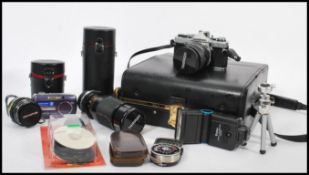 A collection of vintage cameras to include SLR camera body, SLR lenses to include zoom, protective