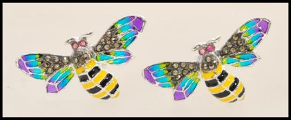 A pair of silver plique a jour cufflinks in the form of bees with green wings and set with