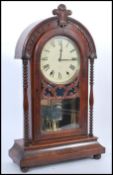 An early 20th century mahogany cased mantel clock raised on a plinth base with bun feet. Glazed door