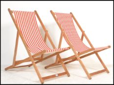 A pair of retro mid 20th century wooden and canvas upholstered deck chairs. The slatted seats with