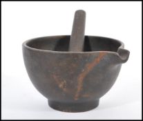 A 19th century cast iron pestle and mortar of simple form with single shaped lip. Bowl 10cm high.