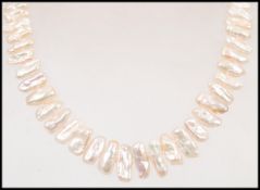 A contemporary cased necklace of Baroque pearls by Baroque pearls being set to a silver celtic