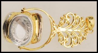 A gold plated pendant locket in the form of a tree having three rotating silver lockets below with