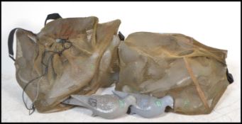A large collection of vintage 20th Century decoy pigeons, the pigeons within two mesh sacks.