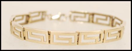 A 9ct gold spacer bracelet having pierced greek key detailing. Weight 12.2g.