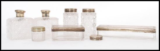 A collection of cut glass and silver hallmarked dressing table lidded pots, the engine turned lids