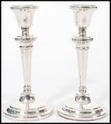 A pair of 20th century silver hallmarked candlesticks raised on stepped circular bases with tapering