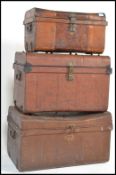 A set of three graduating scrumble painted steamer / tack trunks, all with fitted hinged lids and