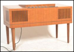 A retro HMV mid century teak wood stereogram having tapering legs with grill front, hinged top