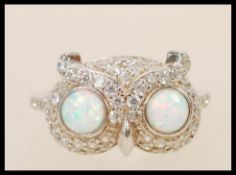 A stamped 925 silver ring in the form of an owl set with two round opals for eyes with cz stones