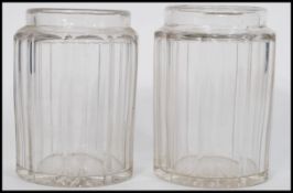A pair of 19th century facet cut glass jars of cyl