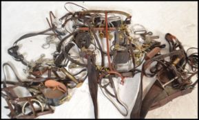A collection of vintage horse tack to include brasses on Martingales, stirrups, reins, bridles,