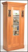 An early 20th Century Edwardian walnut Art Nouveau inspired wardrobe having a central mirrored