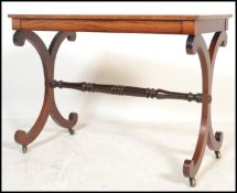 A 19th century Regency mahogany writing table desk being raised on lyre shaped supports united by