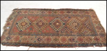 A 19th century Kazak long runner floor rug having four and a half central hooked medallions and
