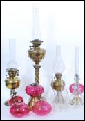 A selection of 19th Century Victorian oil lamps and oil lamp parts to include a brass lamp raised on