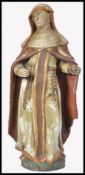 A 19th century carved wooden polychrome figurine of a nun. The religious ecclesiastical adorned in