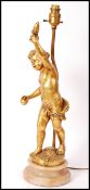 A 20th century classical revival gilt plaster putti / cherub lamp being raised over a veined