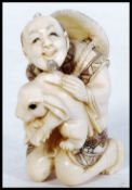 An unusual Japanese Meiji period carved ivory netsuke depicting a merchant man with large rabbit