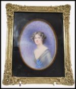 An early 20th century watercolour painting portrait miniature of a young girl debutante holding