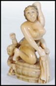 A Japanese Meiji period carved ivory netsuke in the form of a naked Geisha holding her hair whilst