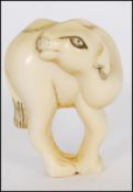 A rare Meiji period ivory Netsuke of a Bactrian camel. The head of the camel turned back standing on