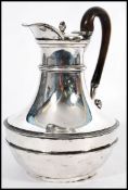 An early 19th century George III silver hallmarked hot water jug by Paul Storr raised on a small