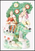 A 19th century Staffordshire Pearlware ceramic figural diorama group of musicians before a tree with