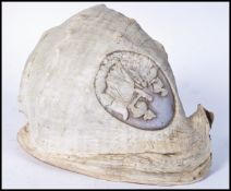 A large 19th century hand carved conch shell of typical form being detailed to top with a roundel